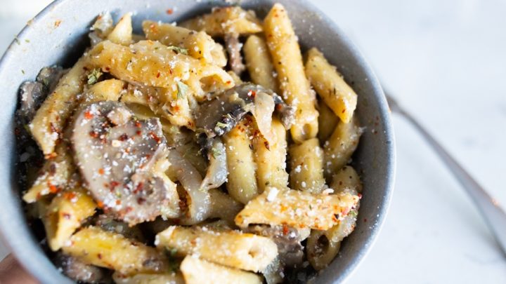 Bowl of one pot mushroom pasta with parmesan cheese on top.