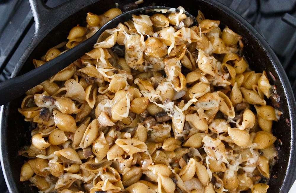 This is a delicious French onion pasta - black cast iron pan filled with shell noodles and caramelized onions.