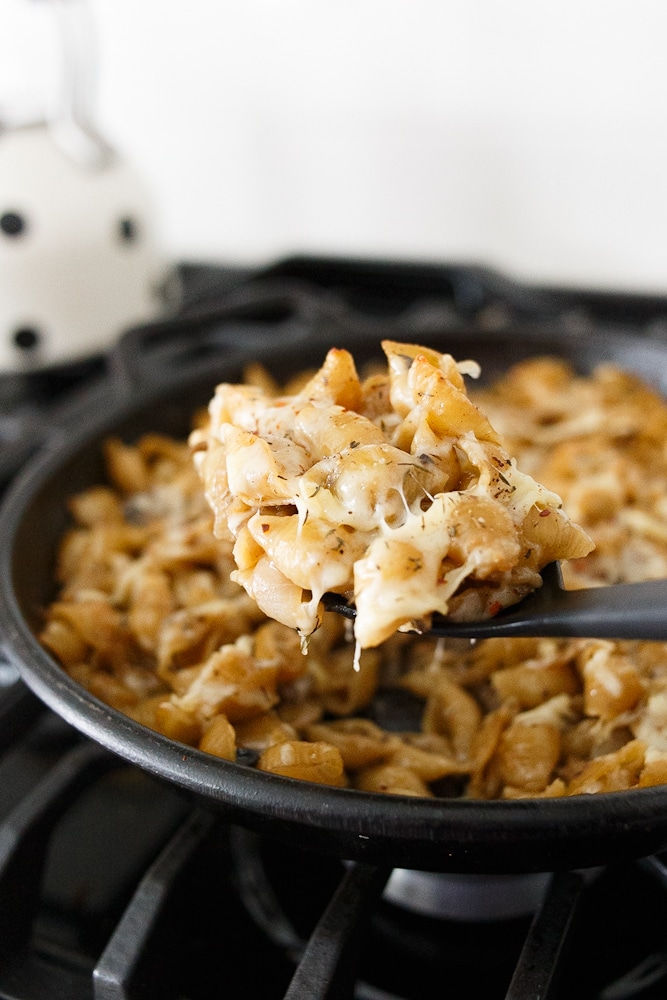 This is French onion pasta - black cast iron pan filled with shell noodles and caramelized onions.